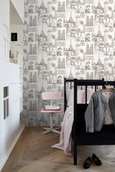 Schlafzimmer mit Fototapete, die Pariser Motive zeigt, darunter den Eiffelturm und die Notre-Dame-Kathedrale.
