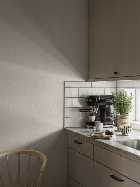 Dekorative Wandgestaltung mit geometrischem Tapetenmuster, Pflanze im Stofftopf und Büchern auf einem Holzregal.