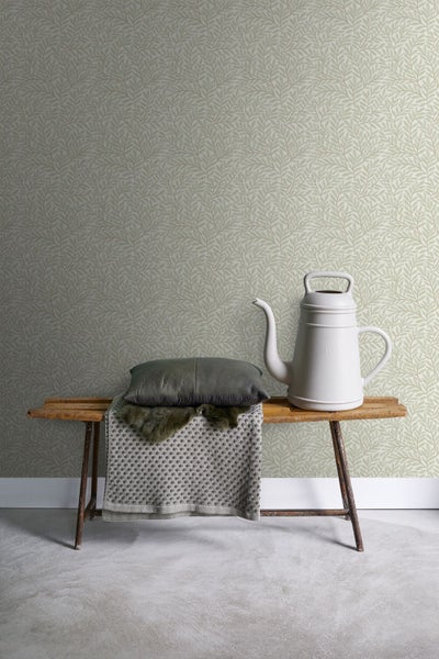 Wandgestaltung mit Blättermuster-Tapete, Bank mit Kissen und Gießkanne