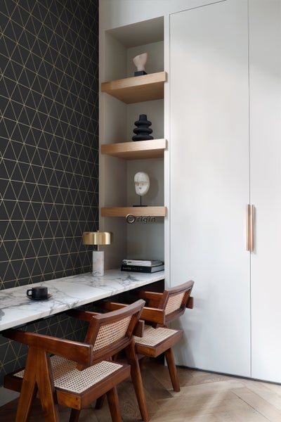 Helles Arbeitszimmer mit Marmorplatte, Holzregalen und zwei Holzstühlen