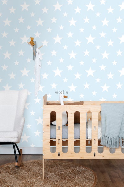 Babyzimmer mit Kinderbett, Schaukelstuhl und Wand mit Sternenmuster