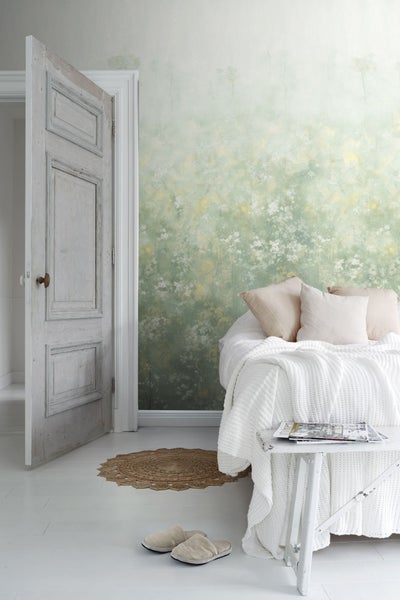 Schlafzimmer mit gemusterter Tapete, Bett und geöffneter Tür