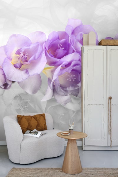 Dekoratives Zimmer mit Sessel, Beistelltisch und einer Fototapete mit Blumenmotiv.