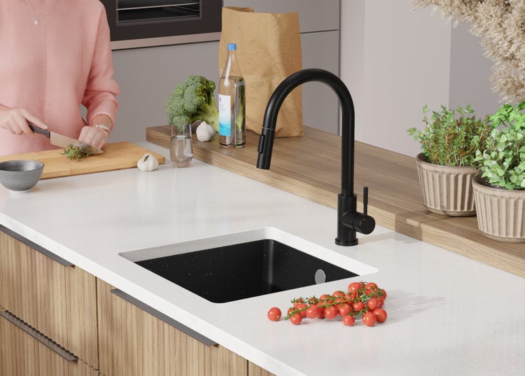 Moderne Küche mit schwarzer Armatur, Spüle und frischen Zutaten