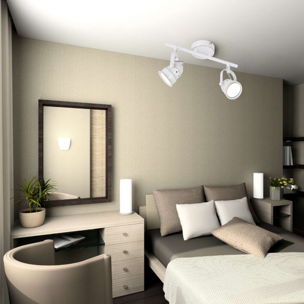 Schlafzimmer mit Doppelbett, Kommode, Spiegel und Deckenleuchte mit Strahlern