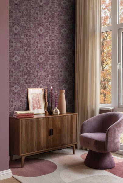 Wohnzimmer mit gemusterter Tapete, Holzschrank, Dekoration und Sessel