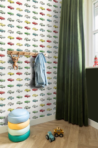 Kinderzimmer mit Tapete mit Automobilmuster, Garderobe mit Jacke, Spielzeug und Sitzgelegenheiten.