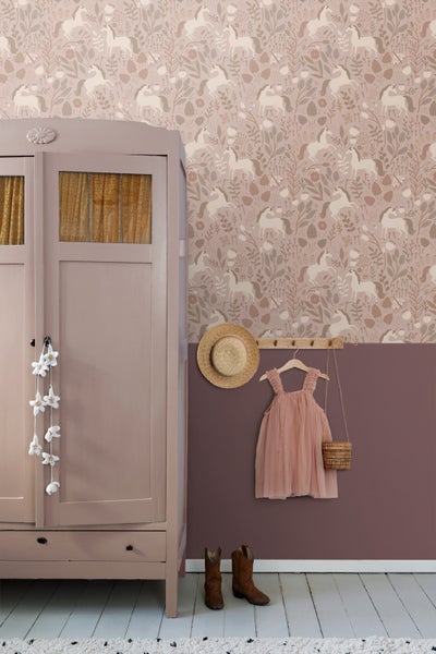 Kinderzimmer mit Schrank, Wandtapete mit Einhornmuster, Hut, Kinderkleid und Stiefeln.