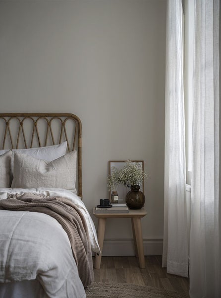 Zwei graue Balkonkästen mit Blumen am Fenstergitter