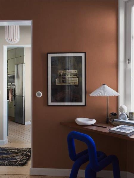 Wohnraum mit Schreibtisch, Stuhl, Lampe und gerahmtem Bild an der Wand