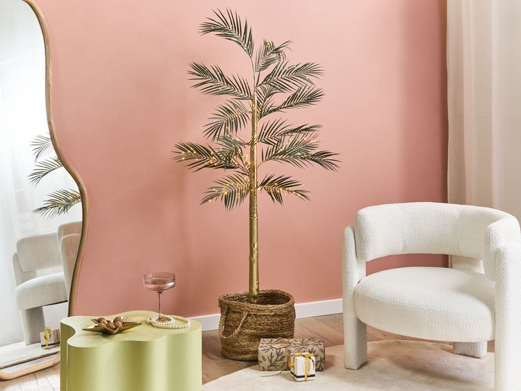 Wohnzimmer-Szene mit Spiegel, Sessel, Beistelltisch, dekorativem Baum und Geschenken für eine gemütliche Raumatmosphäre