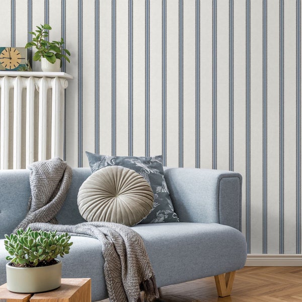 Wohnzimmer mit gestreifter Tapete, Sofa und dekorativen Elementen für eine gemütliche Atmosphäre.