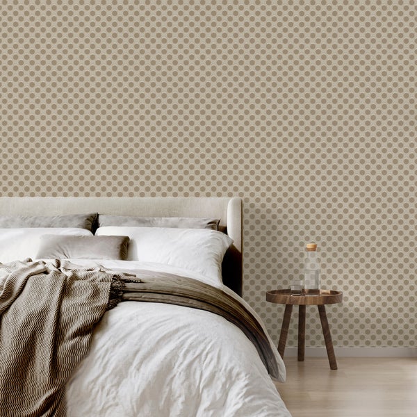 Helles Schlafzimmer mit gemusterter Tapete in Punktoptik, einem Bett mit Kissen und Decke sowie einem runden Beistelltisch aus Holz.