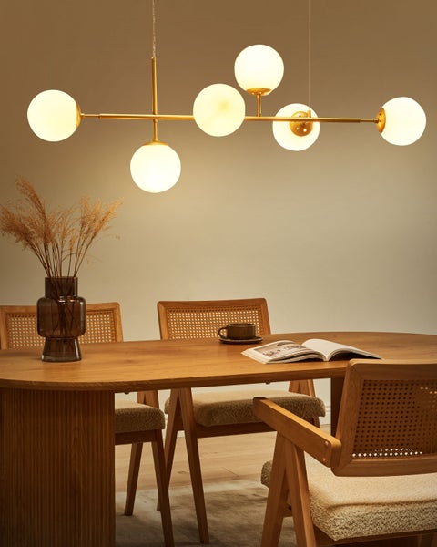 Esszimmer mit Holztisch, Stühlen und Hängelampe mit kugelförmigen Lampenschirmen