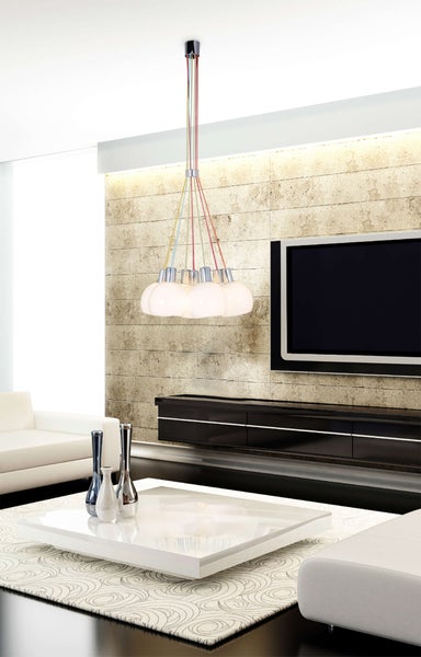 Esstisch mit Stühlen unter einer mehrfarbigen Pendelleuchte.