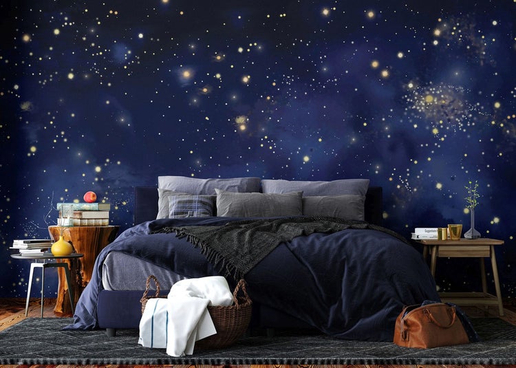 Fototapete mit einem nächtlichen Sternenhimmel und einer Galaxie in einem modern eingerichteten Schlafzimmer.