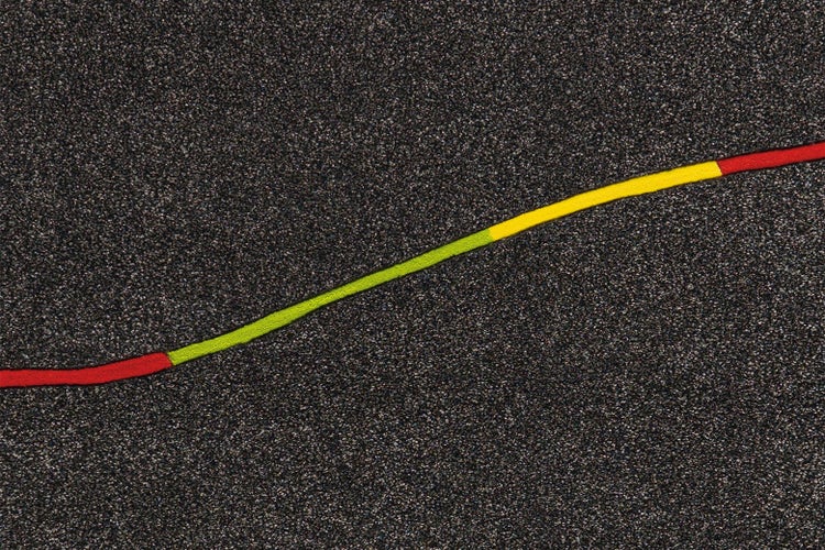 Fallschutzmatte aus Gummigranulat mit einer bunten geschwungenen Linie.