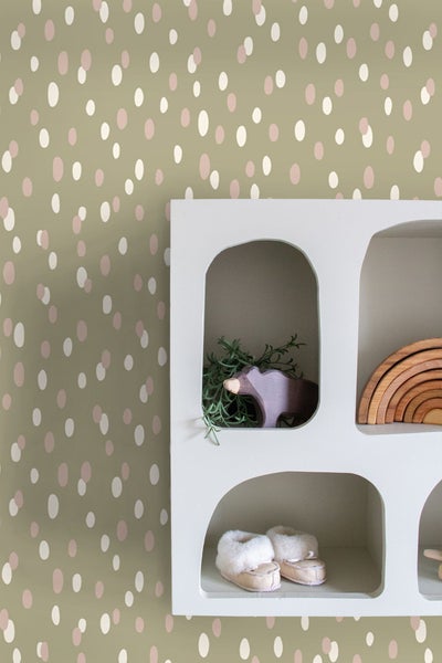 Dekorative Wand mit Tupfenmuster und weißem Regal mit Accessoires
