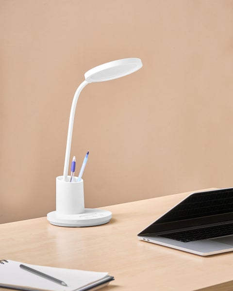 Schreibtischszene mit einer weißen LED-Lampe mit Stifthalter neben einem Notebook und einem Notizblock