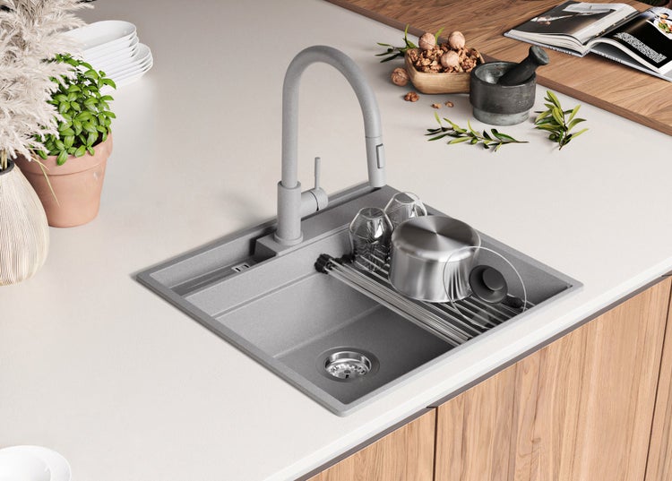 Küchenspüle mit Abtropfgestell und Armatur auf einer Küchentheke