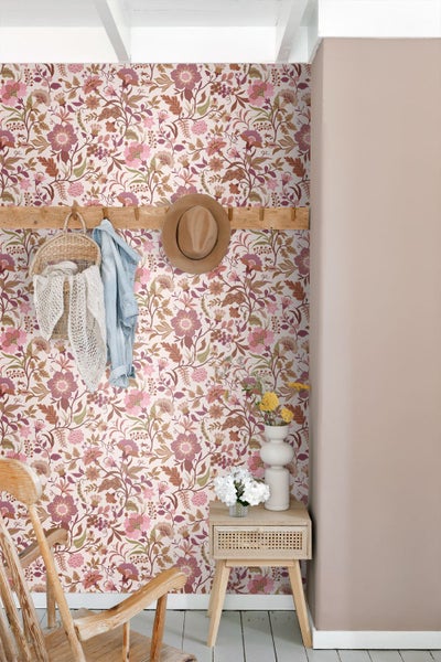 Schlafzimmer mit floraler Tapete, weißem Holzbett, gelbem Nachtschrank und gemusterter Bettwäsche.