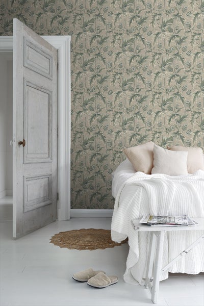 Dekoratives Zimmer mit floraler Tapete, Sofa und Zimmerpflanze.