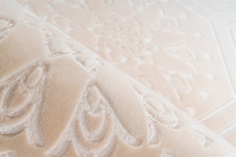 Nahaufnahme eines weichen, flauschigen Teppichs mit geprägtem ornamentalem 3D-Muster.