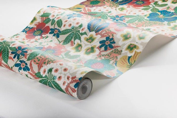 Wohnzimmer mit floral gemusterter Tapete, Sofa und Dekoration