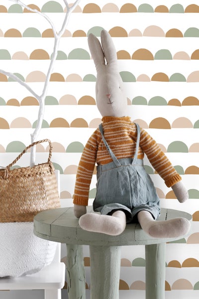 Dekorative Szene mit Stoffhase auf einem Tisch vor einer gemusterten Tapete