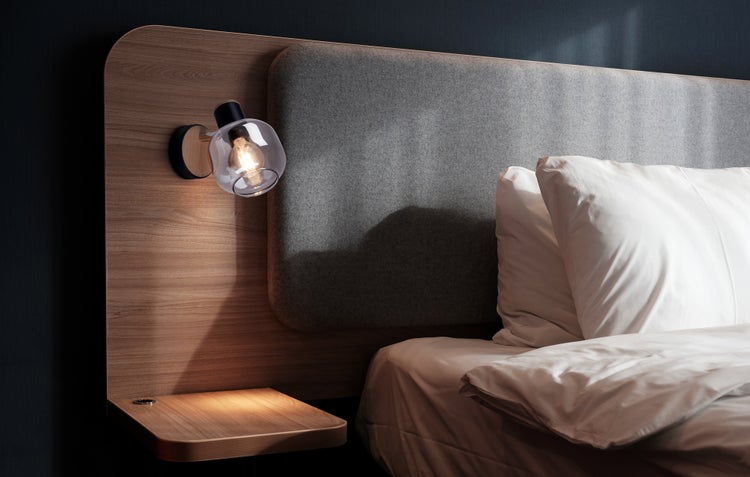 Modernes Schlafzimmer mit Holzbettgestell, gepolstertem Kopfteil und schwenkbarer Wandleuchte