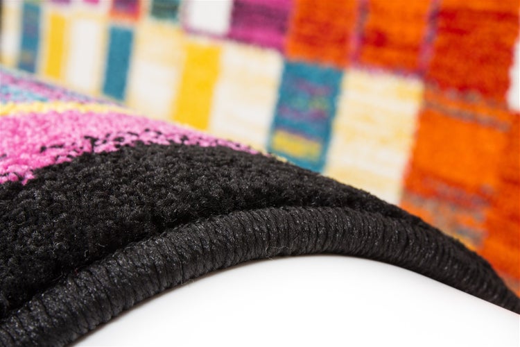 Nahaufnahme eines bunten Teppichs mit schwarzer gekettelter Kante.
