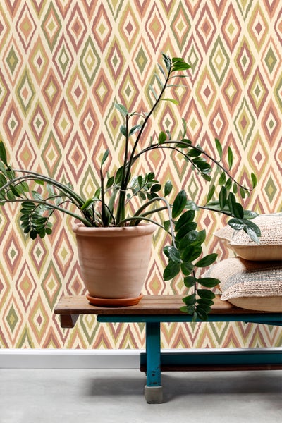 Szene mit gemusterter Tapete, Pflanze im Topf und Kissen auf einer Bank