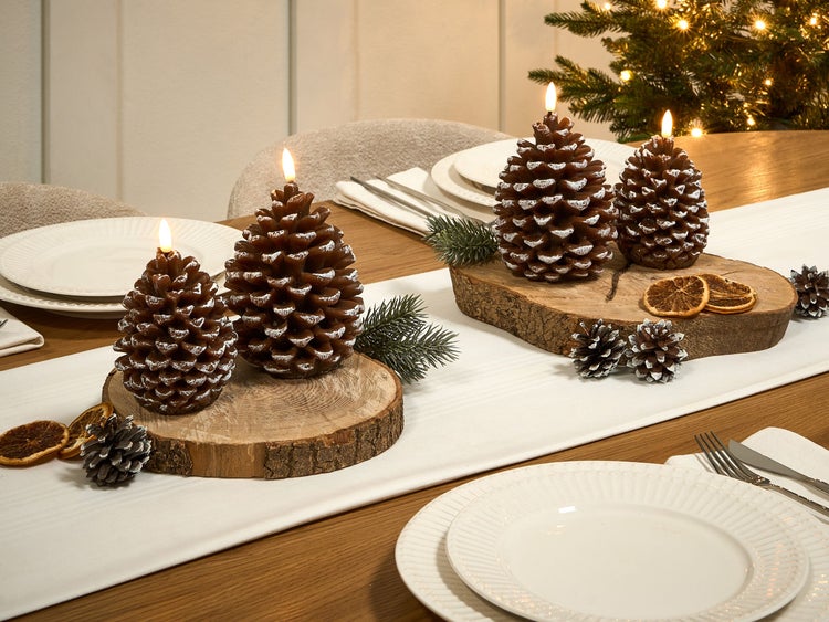 Festlich gedeckter Tisch mit Tannenzapfenkerzen und Weihnachtsdekoration