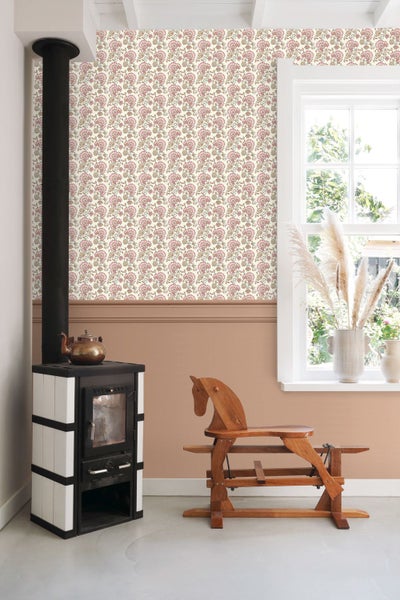 Wohnraum mit Ofen, Holzpferd und gemusterter Tapete