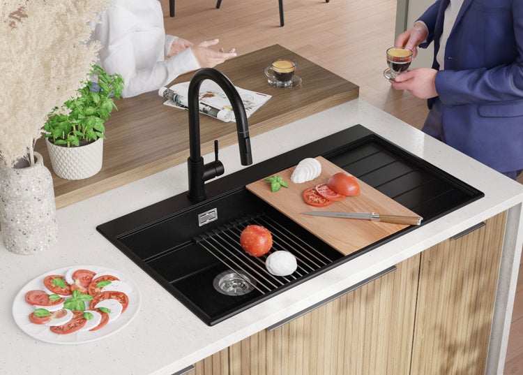 Spüle mit Abtropffläche, Schneidebrett, Armatur und Zutaten auf einer Küchentheke