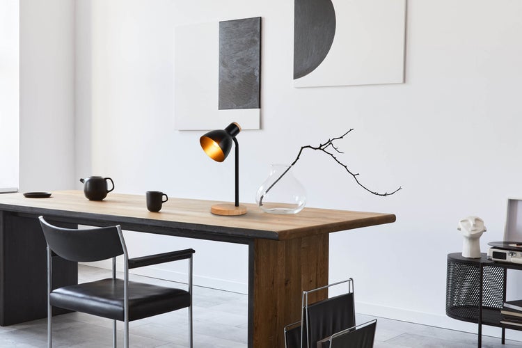 Helles Zimmer mit Esstisch, Stühlen, Tischlampe und Dekoration