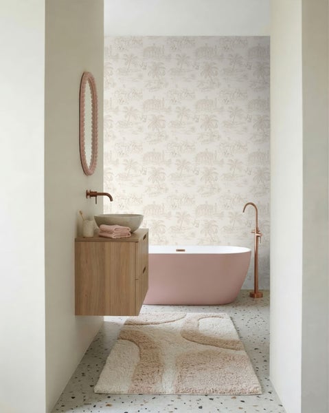 Modernes Badezimmer mit freistehender Badewanne, Waschtisch aus Holz mit Steinbecken, Kupferarmaturen und gemusterter Tapete mit Palmenmotiven.