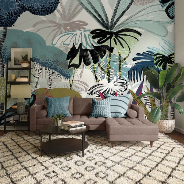 Wohnzimmer mit Sofa, Couchtisch, Regal und tropischer Tapete