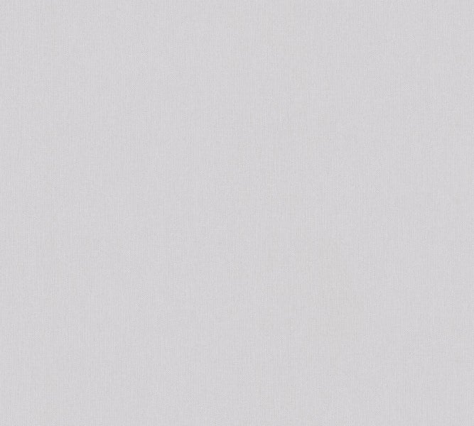 Fuchsienpflanze mit roten Blüten im Gartenbeet.