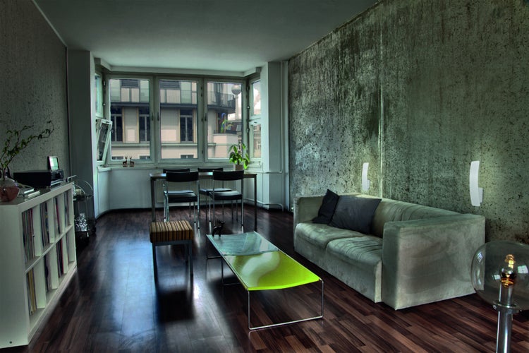Wohnzimmer mit Sofa, Tisch, Stühlen und Bücherregal