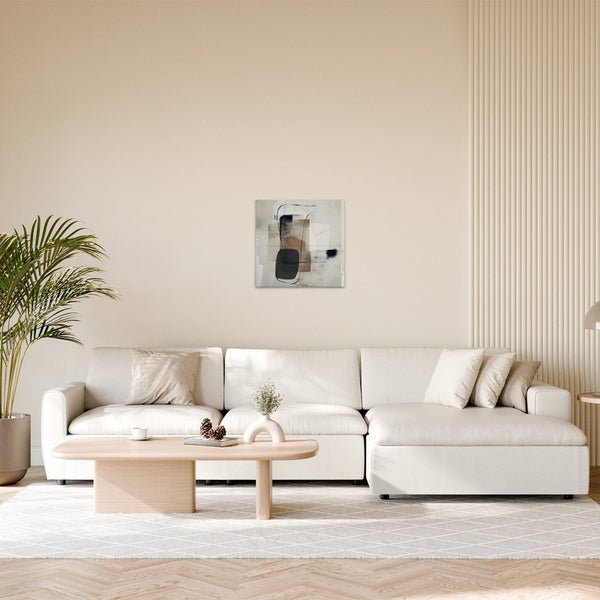 Wohnzimmer mit hellem Sofa, Couchtisch und abstrakter Wandkunst