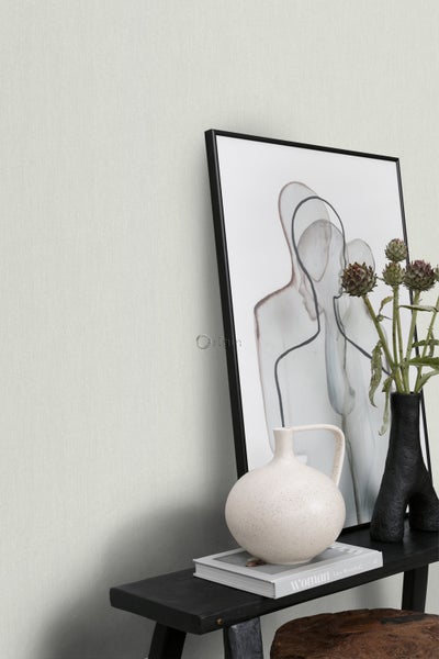 Dekoratives Stillleben mit Vase, Buch und gerahmtem Bild auf einem schwarzen Regal.