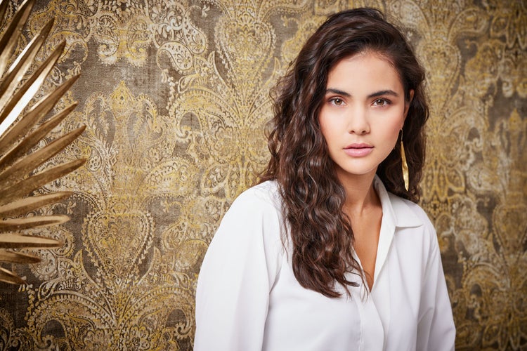 Dekorative Vase auf einem Regal vor einer verzierten Wand