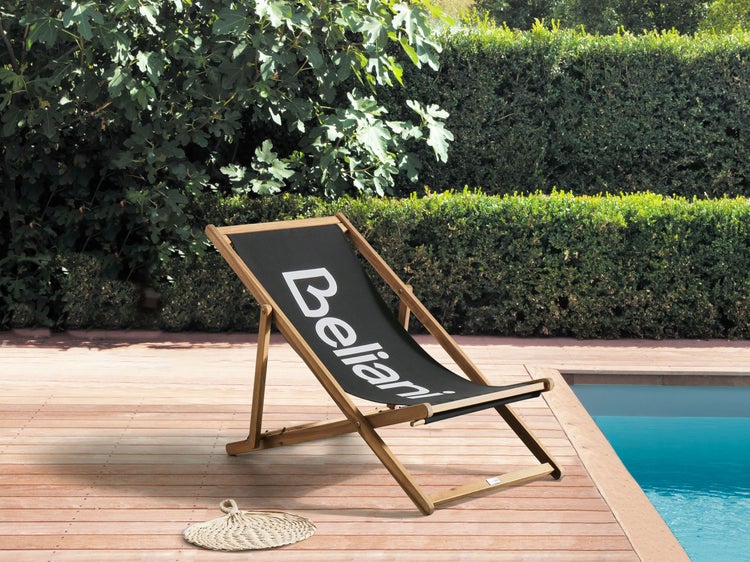Holzliegestuhl mit Stoffbezug neben einem Pool