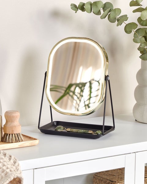 Beleuchteter Kosmetikspiegel mit Ablage und Jade-Gesichtsroller auf einem Tisch