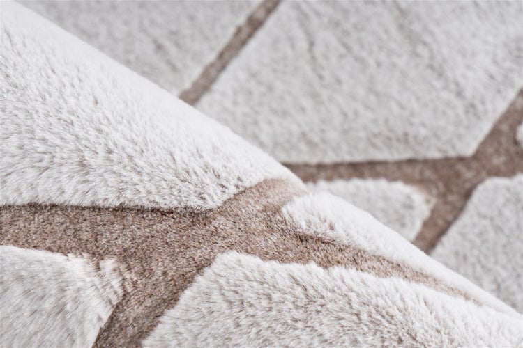 Detailansicht eines weichen Hochflor-Teppichs mit geometrischem Muster und flauschiger Textur.