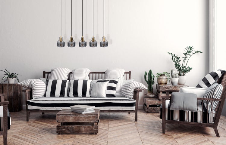Wohnzimmer mit Sofa, Sessel, Pflanzen und dekorativer Beleuchtung