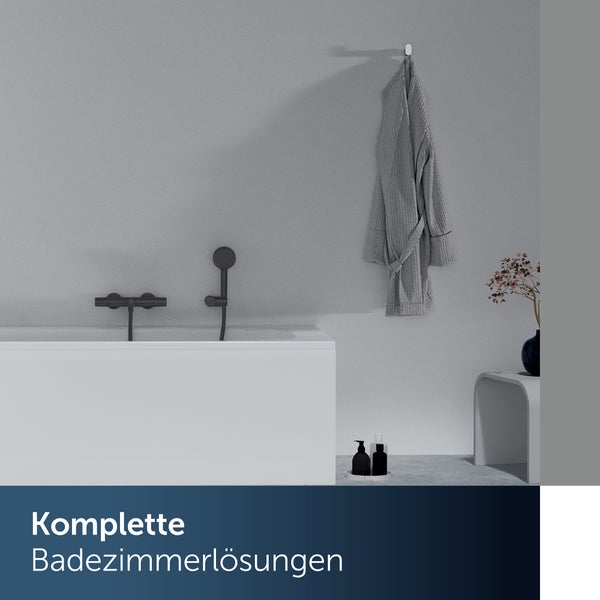Moderne und minimalistische Badezimmerlösung mit Badewanne, Armatur, Handtuch und Dekoration in schlichtem Design