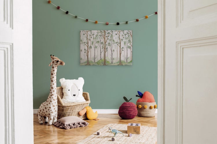 Kinderzimmer mit Wald Bild an der Wand, Rattansessel, Kuscheltieren und Holzspielzeug auf dem Parkettboden.
