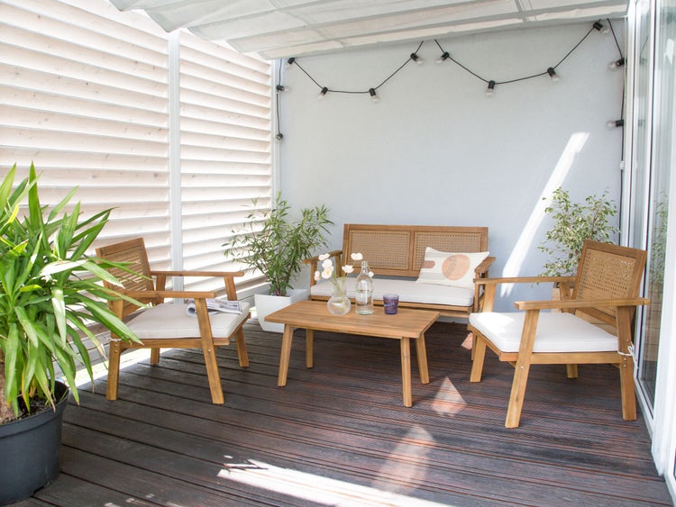 Terrasse mit Holzmöbeln, bestehend aus Bank, Tisch und Stühlen